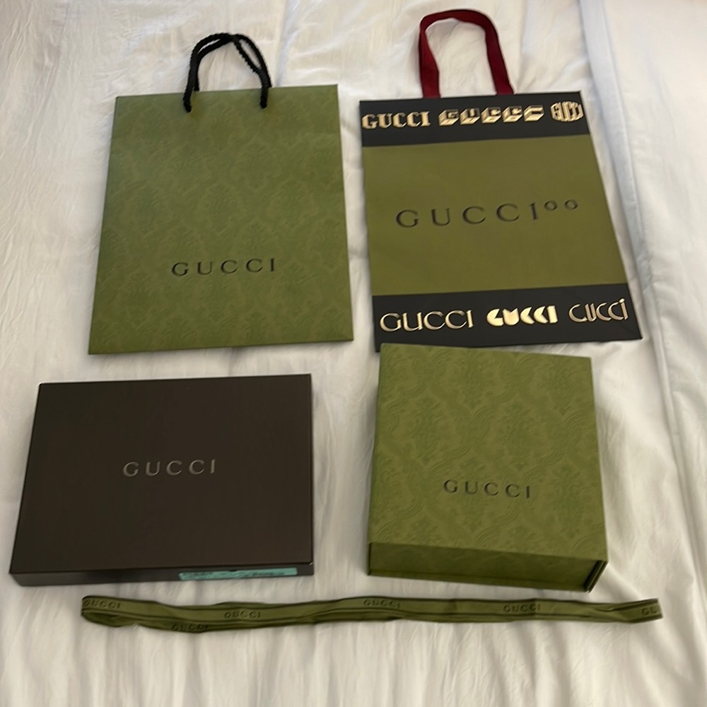 Two Gucci boxes with two Gucci bags along with a matching  Gucci ribbon